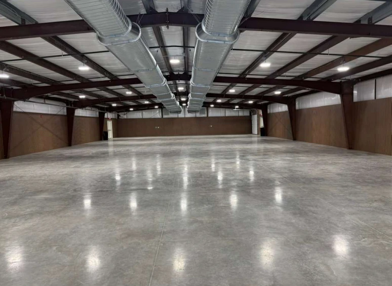 Empty industrial warehouse interior with exposed beams.
